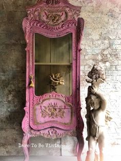 a pink cabinet sitting next to a statue