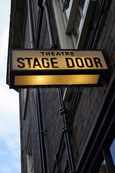 the theatre stage door sign is lit up in front of a brick building stock images