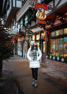 a woman standing in front of a christmas store