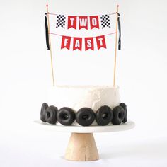 a white cake topped with black donuts and a two flags banner on top of it