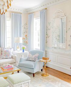 the living room is decorated in pastel colors and floral wallpaper, along with white furniture