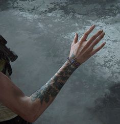 a man with tattoos on his arm holding out his hand