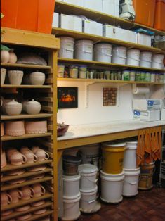 the shelves are filled with many pots and pans