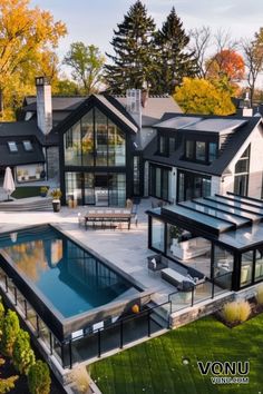 A luxurious modern home with a sleek outdoor pool and spacious patio, surrounded by lush greenery and autumn trees. Modern Coastal Home Exterior, Coastal Home Exterior, Beautiful Houses Exterior, Creative Bathroom Design, Neutral Bedroom Design, Home With Pool, Modern Coastal Home, Modern Entrance