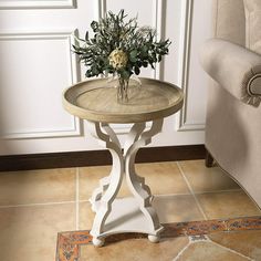 a small table with flowers on it sitting in front of a chair and door way