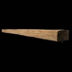 a close up of a wooden shelf against a black background