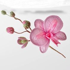 a crocheted pink flower on a white background