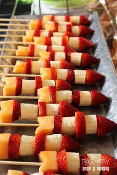 strawberries and cheese skewers on sticks are ready to be served at an outdoor party