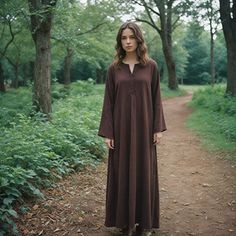 This brown medieval gown is an outstanding example of simplicity and elegance and is sure to please anyone seeking an authentic historic costume. This simple design, with its long sleeves and flowing silhouette, makes it perfect for a Renaissance fair, Norse reenactment, or really any themed event. This flowing gown is thoughtfully designed to make use of soft, comfortable fabric, draping easily for movement but still reflecting the period look. Whether preparing for a festival or stepping into Pretty Body, Flowing Gown, Medieval Gown, Fabric Draping, Viking Reenactment, Larp Costume, Steampunk Cosplay, Long Tunic, Women's Costumes