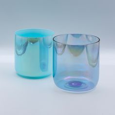 two blue glass vases sitting next to each other