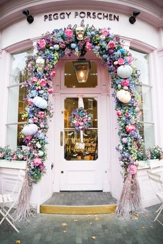 a pink store front decorated with flowers and decorations