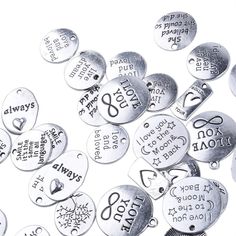 lots of silver colored metal buttons with words and hearts on them that say i love you