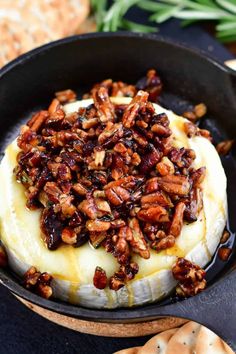 baked mashed potatoes topped with pecans in a cast iron skillet