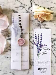 the wedding stationery is laid out on top of the marble table with flowers and wax stamp