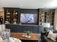 a living room filled with furniture and a large flat screen tv mounted to the wall