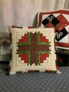 two decorative pillows sitting on top of a bed