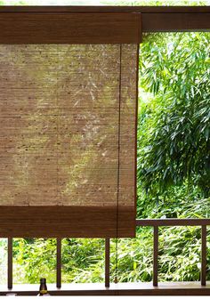 bamboo blinds on a balcony with trees in the background