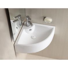 a white sink sitting next to a mirror in a bathroom under a faucet