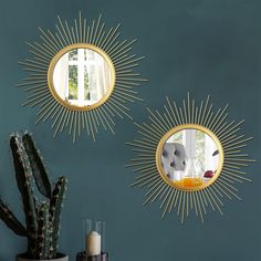 two mirrors on the wall above a table with a cactus in front of it and a potted cacti