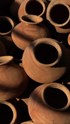 many clay pots are stacked on top of each other