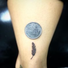 a small tattoo on the leg of a woman with a penny in it's lap