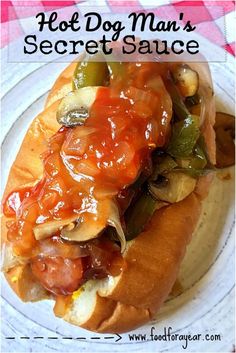 a hot dog covered in condiments sits on a plate with a checkered tablecloth