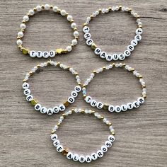 four bracelets with beads and words on them