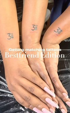 two women with matching tattoos on their arms and hands, both holding each other's hands