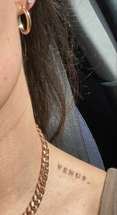 a close up of a person with a tattoo on their neck and behind her ear