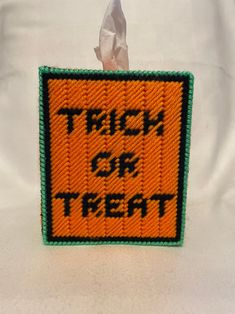 an orange and green patch with the words trick or treat written in black on it