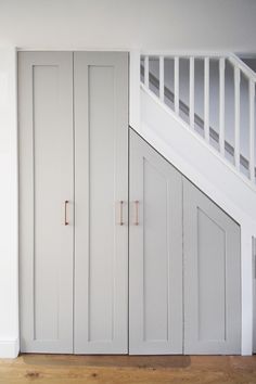 an empty room with white cupboards and stairs