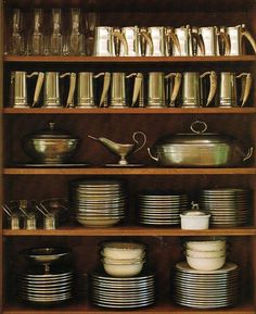 a wooden shelf filled with lots of plates and pans