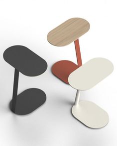 three different colored chairs sitting next to each other on a white surface and one has a wooden table top