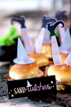 small sandwiches with witches on them sitting on a table next to other food and decorations