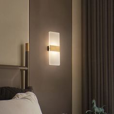 a wall light that is on the side of a bed