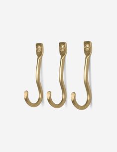 three brass hooks on a white background