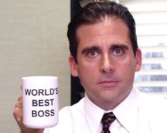 a man holding a coffee mug with the words world's best boss on it