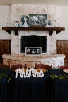 a fireplace in a room with pictures on the mantel and table cloths around it