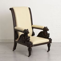 an antique chair with carved wood and leather upholstered on the armrests