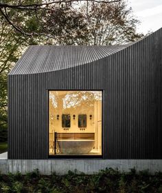 a black house with an open window and a bathtub in the middle of it