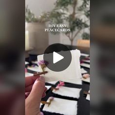 someone holding a piece of paper with flowers on it and the words diy easy place cards