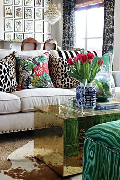 a living room filled with lots of furniture and flowers on top of a coffee table