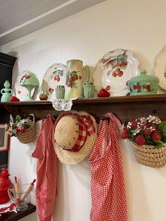 a shelf filled with dishes and hats hanging from it's sides on top of a wall