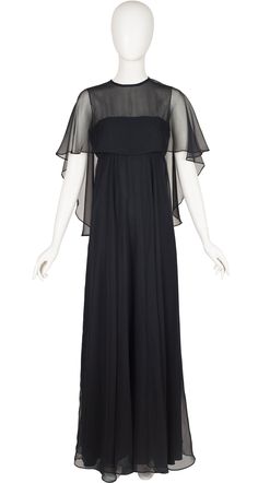 "This 1970s Jean Varon floor length evening dress was made in England of a lined black polyester chiffon. As with all classic Jean Varon, it was designed by John Bates. It features an empire waist and a built-in chiffon overlay with tassels at the back. It does up the back with a YKK zipper and a button at the back of the neck. It's in excellent, ready-to-wear condition. Measurements: Bust - 35\" Empire waist - 29\" Hips - 38\" Length - 61\" IMPORTANT NOTE FOR CANADIAN SHOPPERS: There is a 15% s Sheer Silk Chiffon Maxi Dress For Evening, Formal Black Silk Chiffon Maxi Dress, Black Silk Chiffon Maxi Evening Dress, Black Silk Chiffon Party Maxi Dress, Chiffon Empire Waist Evening Dress, Chiffon Maxi Dress With Empire Waist For Evening, Black Silk Chiffon Evening Dress For Formal Occasions, Black Silk Chiffon Evening Dress, Black Silk Chiffon Evening Dress For Party