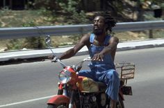 a man riding on the back of a motorcycle down a street