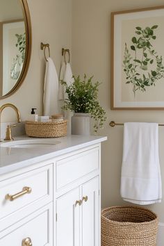 a bathroom with white cabinets and gold accents