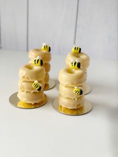 three donuts covered in frosting and honeybees on top of each other