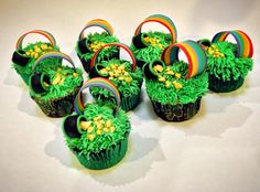 cupcakes with green frosting and rainbow decorations