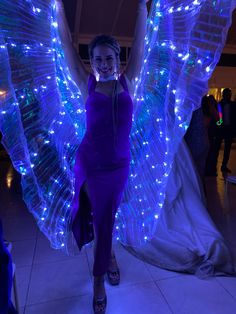 a woman is dressed up like an angel with lights on her wings and headphones