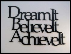 the words dream it, believe it, achieve it written in black on a white wall